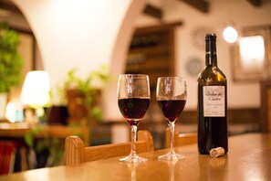 Two wine glasses on a table with a bottle of wine and a cork. - Inn of Amigos Yasuda Pension (Takayama)