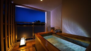 A wooden deck with a hot tub and a lantern. - Toba Grand Hotel (Toba)