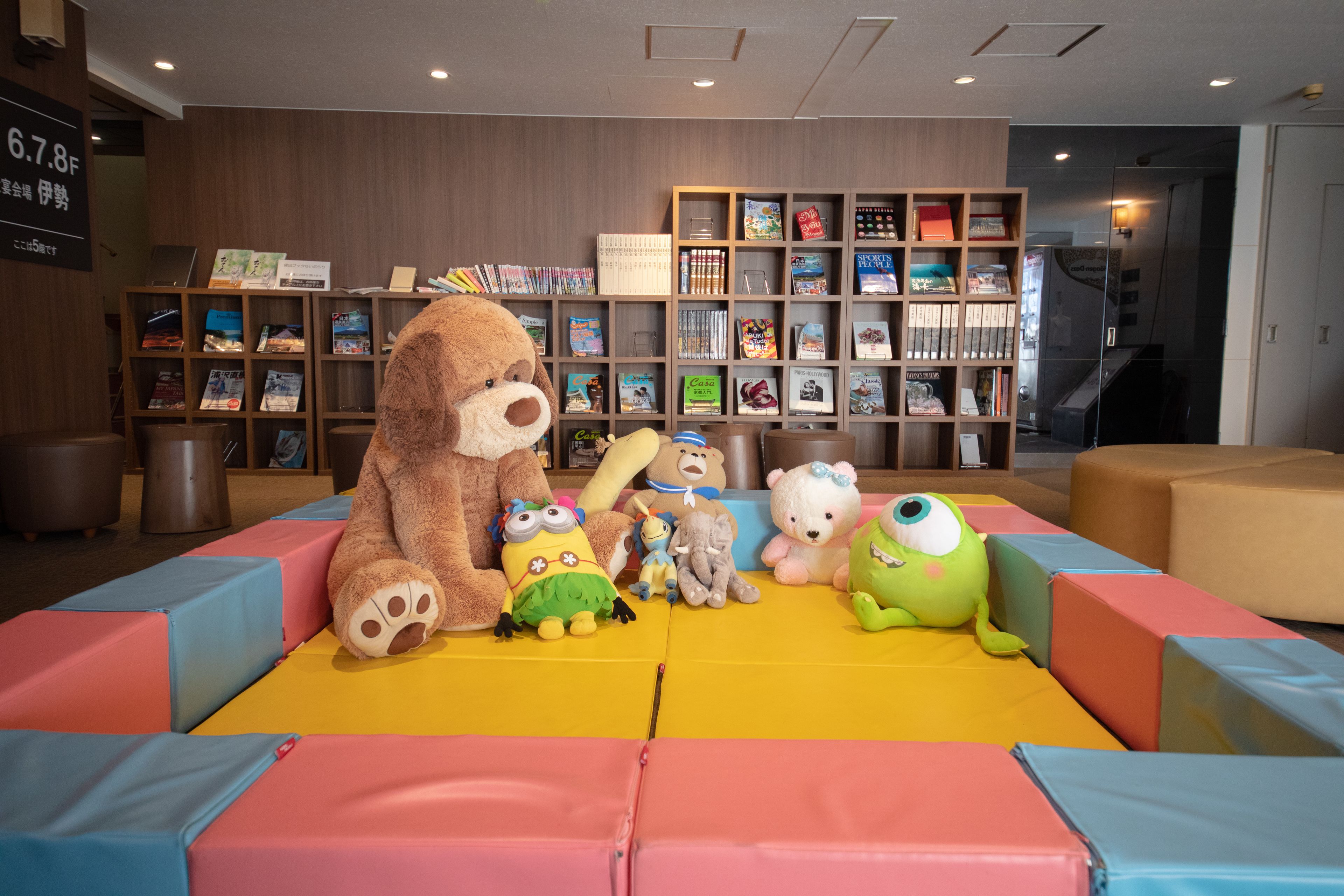 A children's play area with colorful padded seating and various stuffed toys.