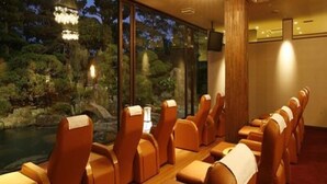 A room with rows of leather chairs facing a large window overlooking a natural landscape. - Hotel Rich Garden (Izumo)