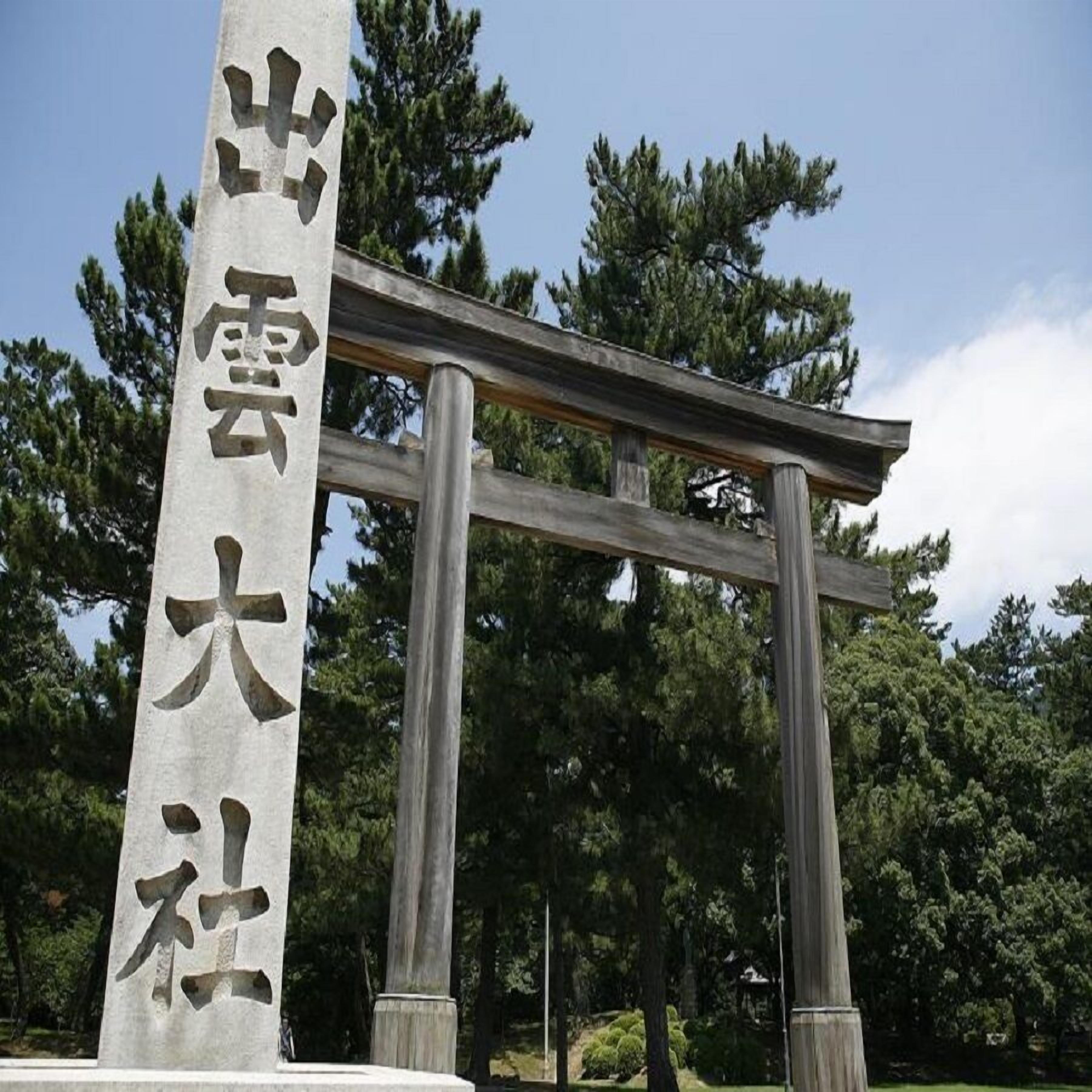 A traditional Japanese torii gate with a stone pillar inscription.