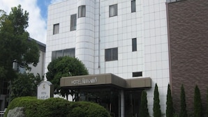 A modern hotel with a distinctive white facade and a sign reading "HOTEL RICH GARDEN". - Hotel Rich Garden (Izumo)
