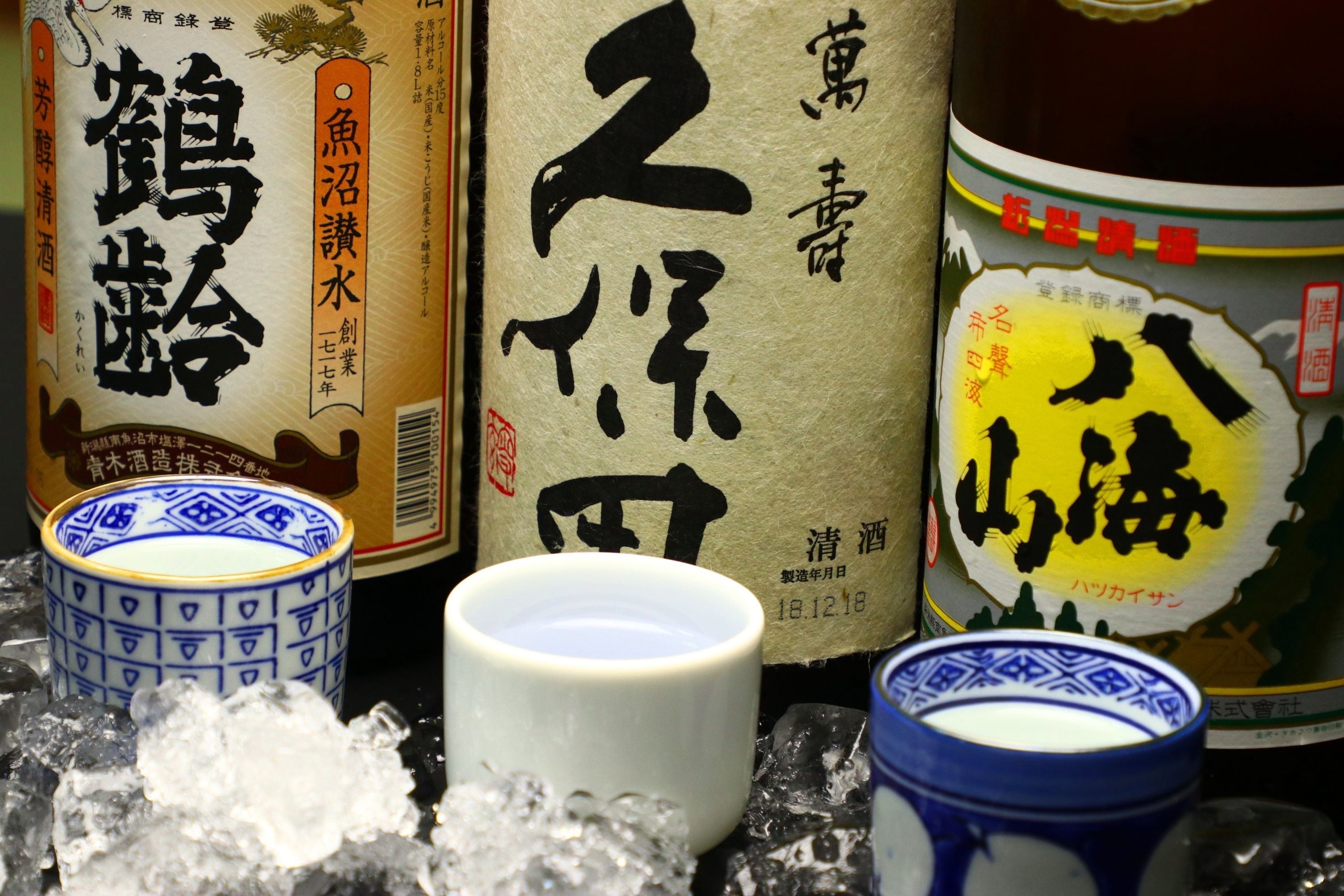 A selection of Japanese sake bottles and traditional ceramic cups.
