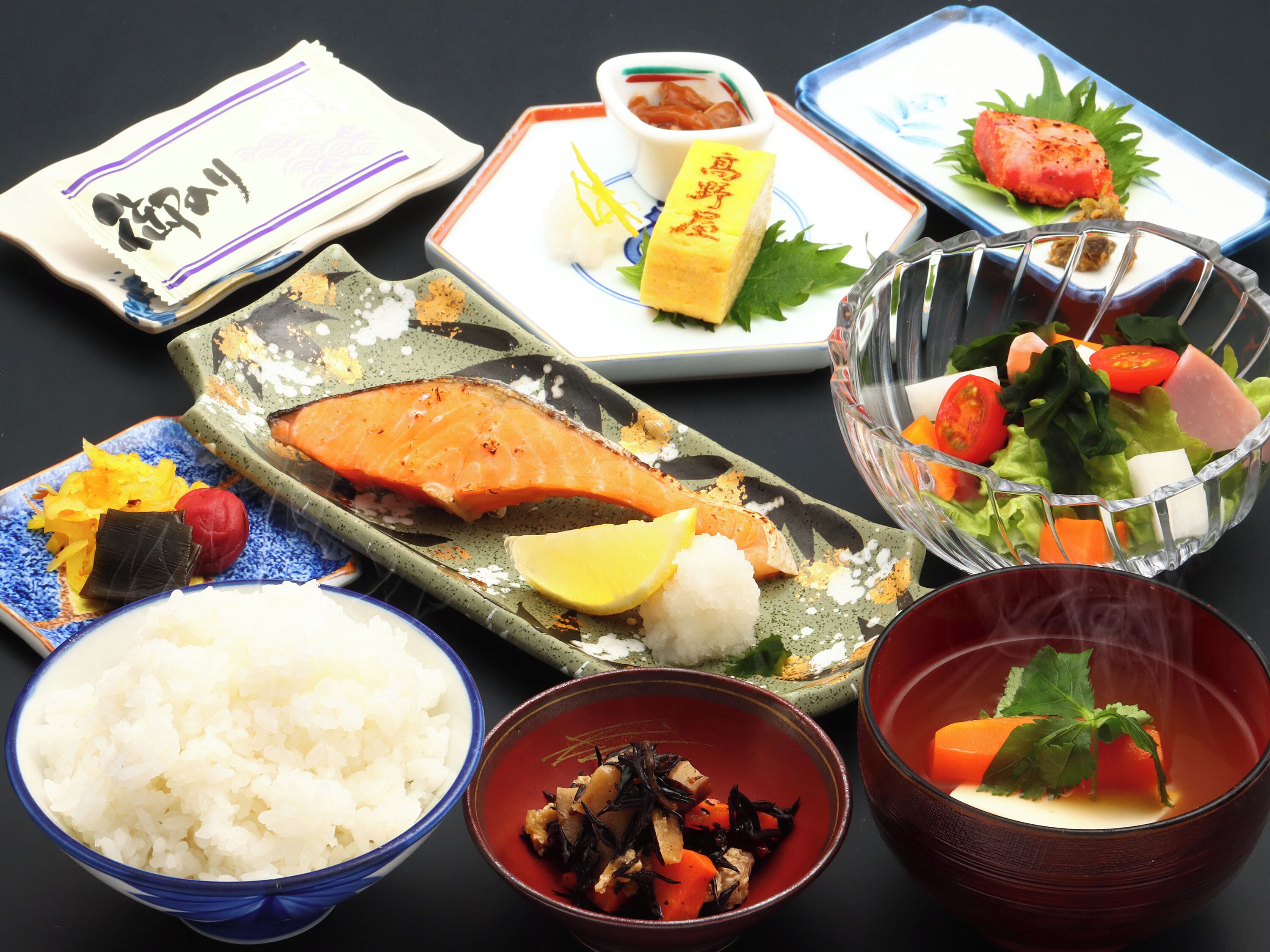 A variety of Japanese dishes including sushi, rice, and a bowl of soup.