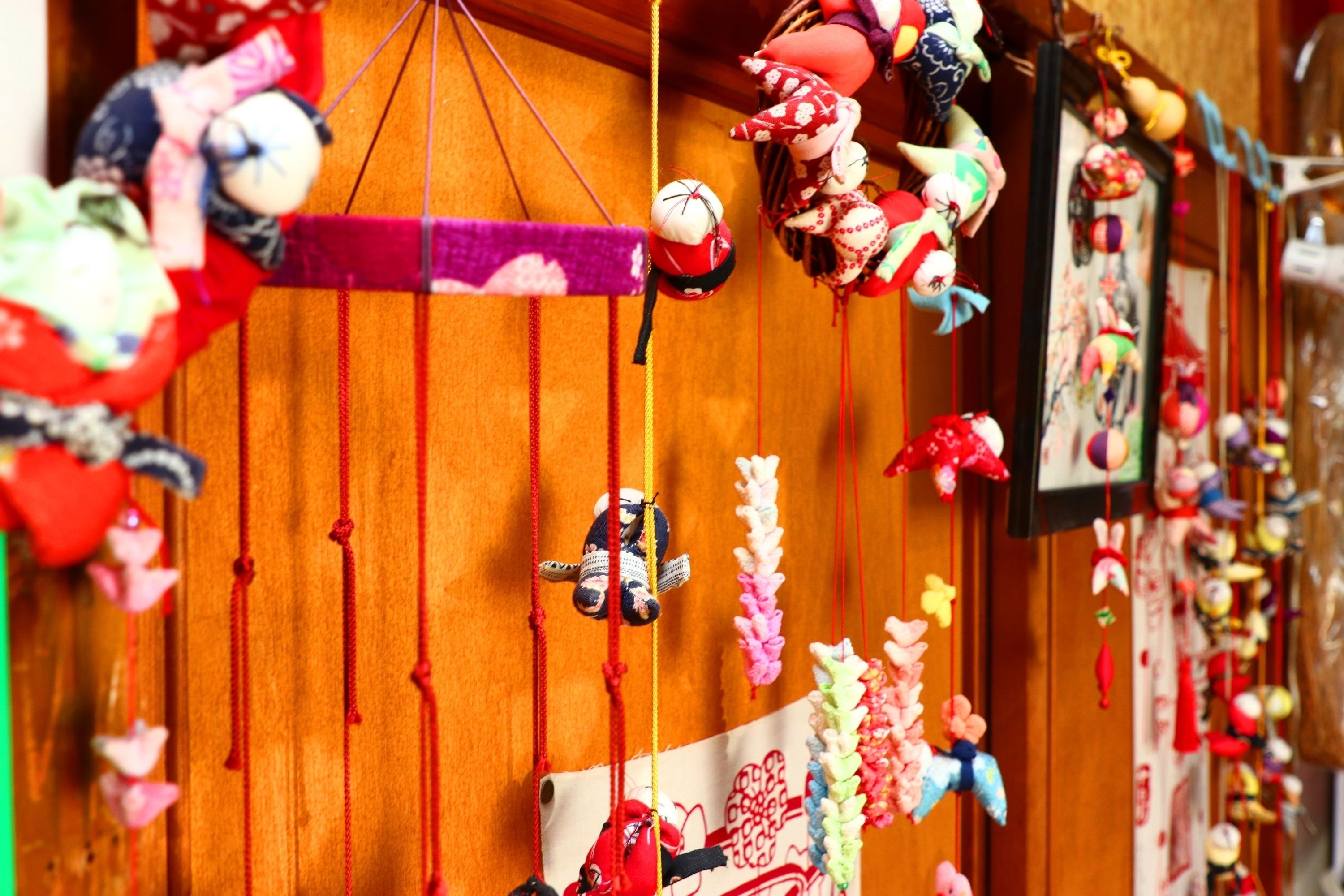 A room with wooden walls and a variety of hanging decorations, including plush toys and colorful ornaments.