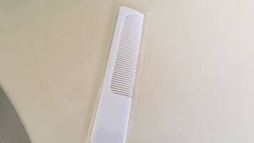 A white comb on a beige surface.