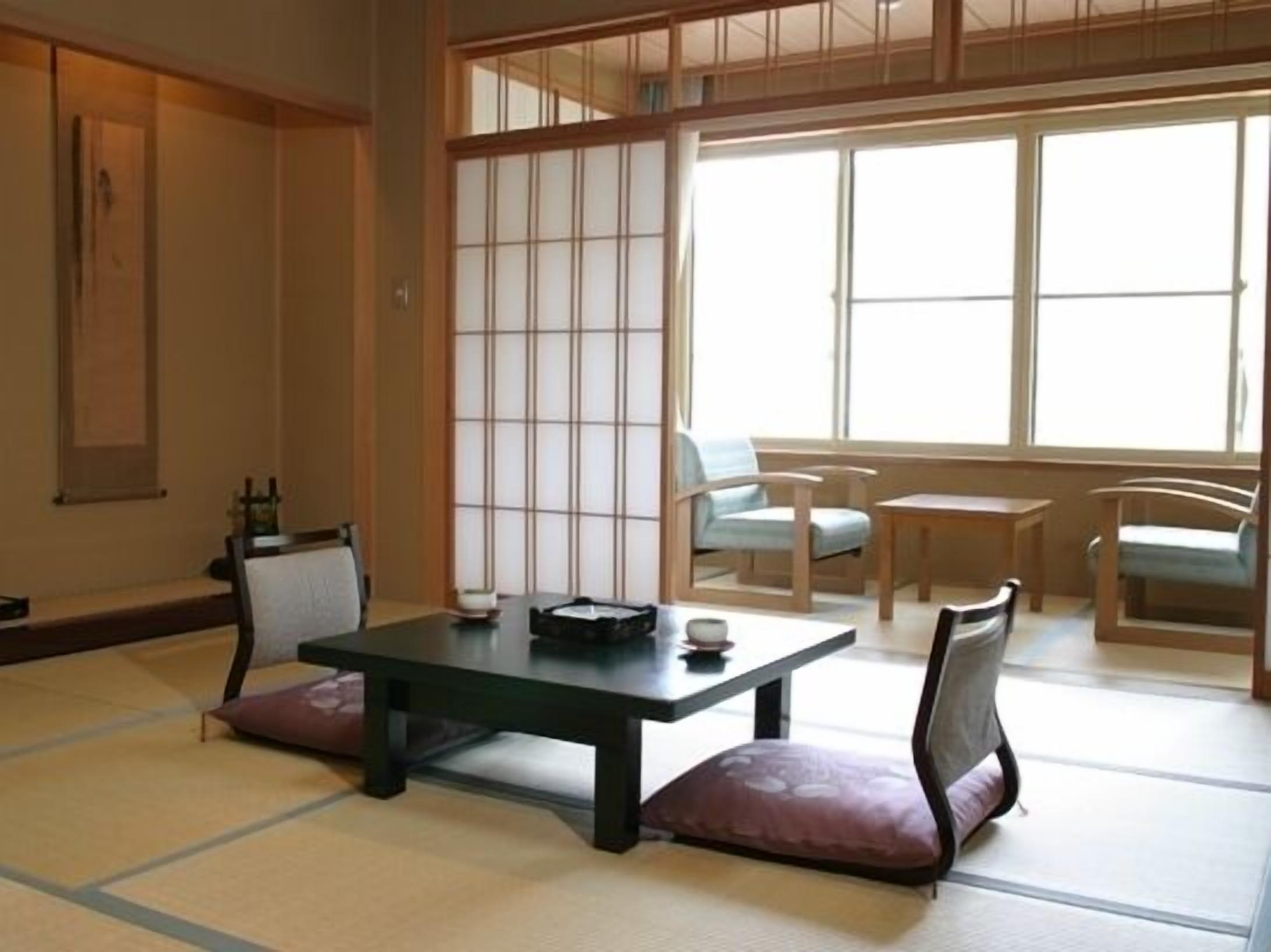 Una habitación japonesa tradicional con suelo de tatami, una mesa baja y un shoji corredizo.