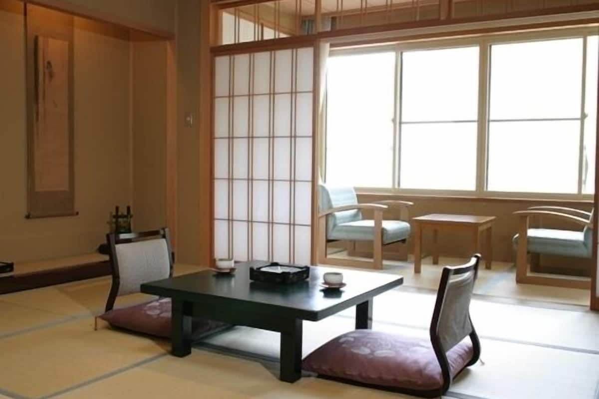 Een traditionele Japanse kamer met tatami vloerbedekking, een lage tafel en een schuifdeur van shoji-papier.
