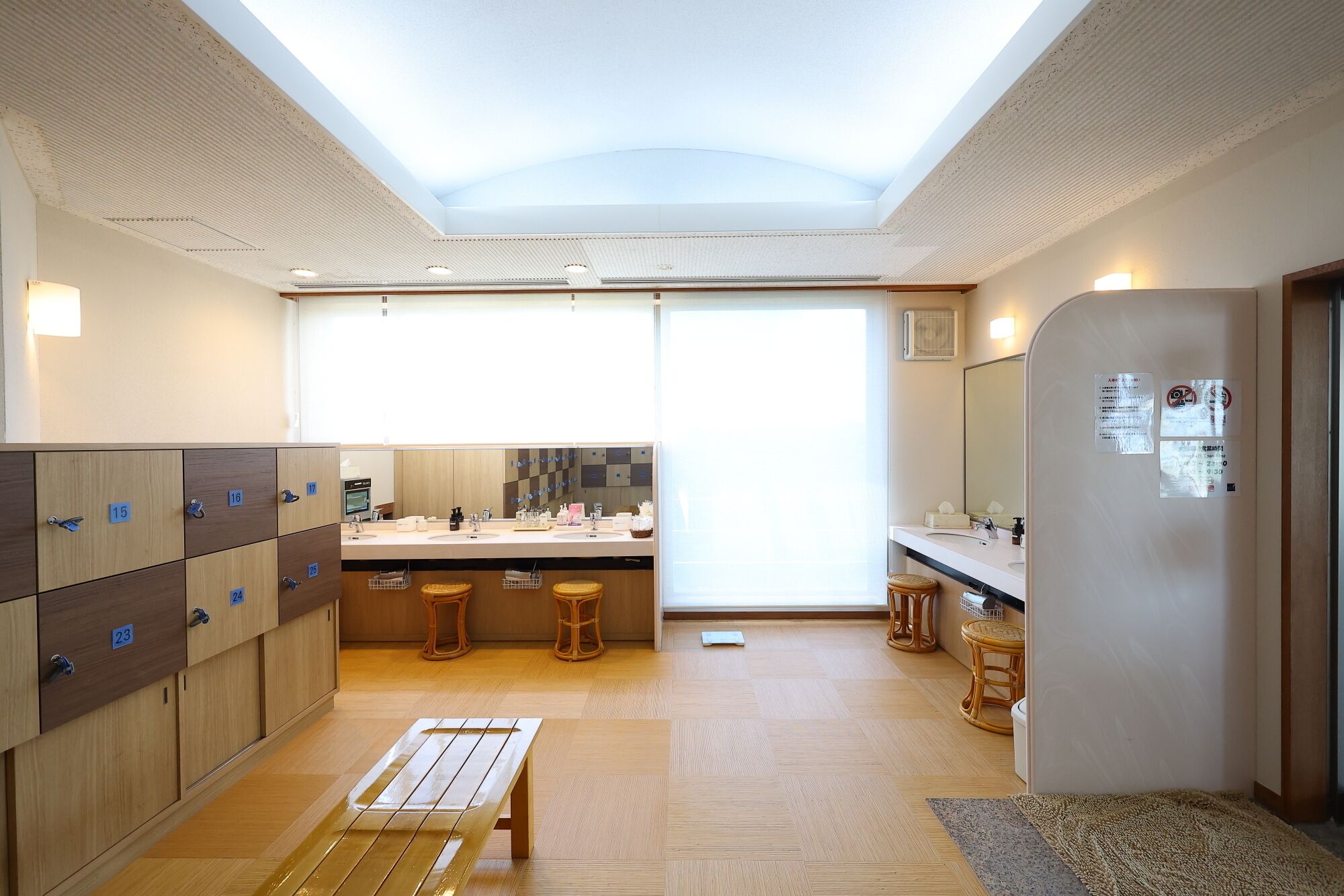 Una cocina moderna con una isla central, armarios de madera y un amplio ventanal que proporciona luz natural.
