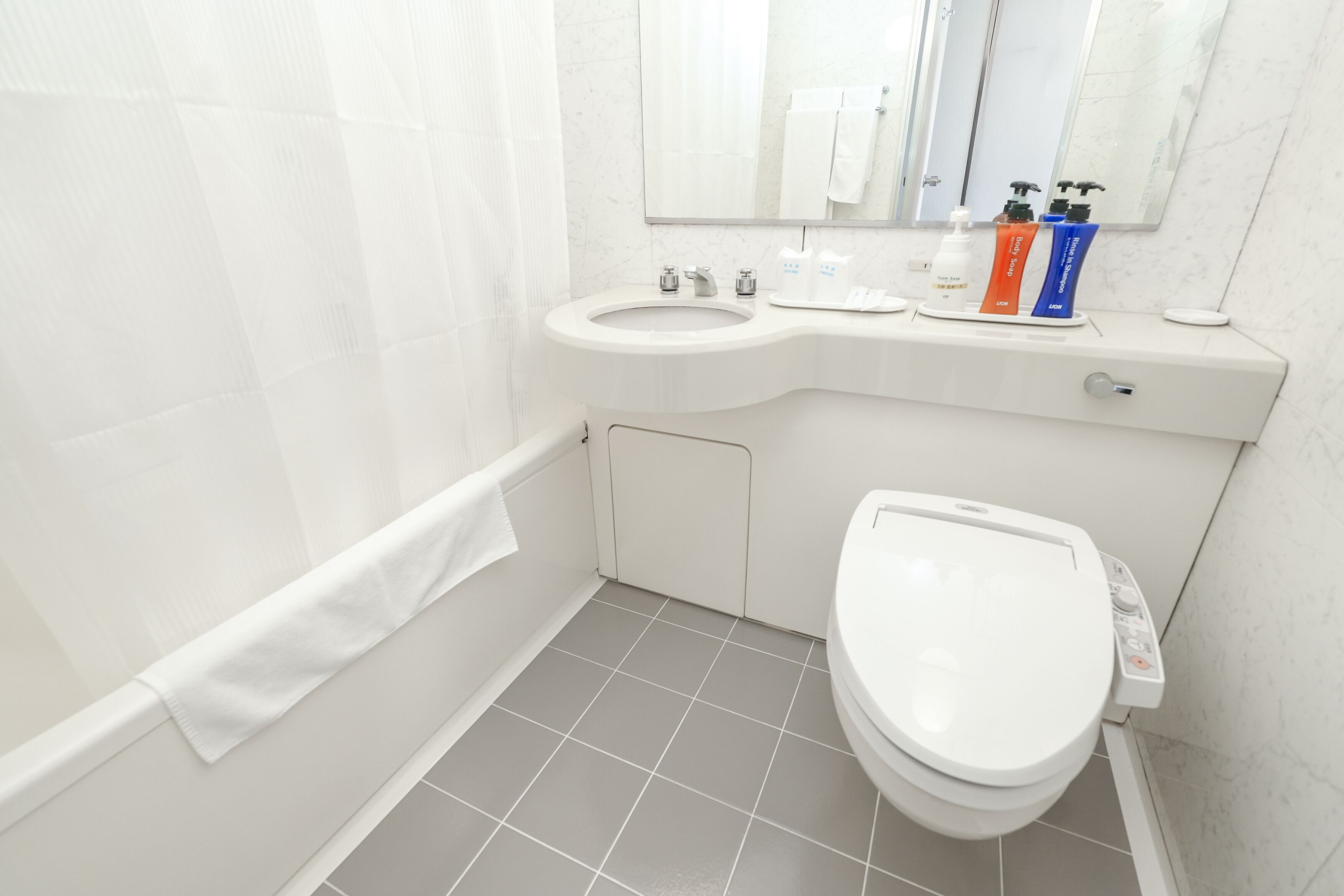 Un baño moderno con inodoro, lavabo y zona de ducha.