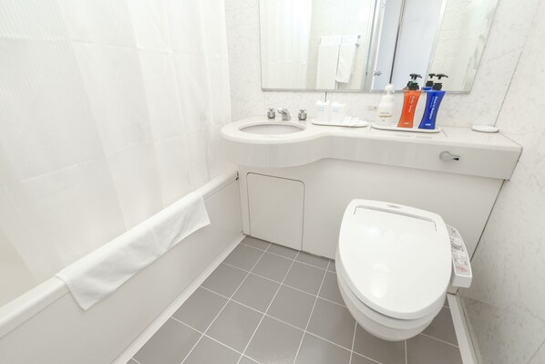 A modern bathroom with a toilet, sink, and shower area.