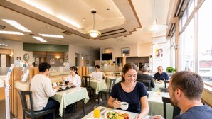 Un comedor con mesas, sillas y una variedad de alimentos.