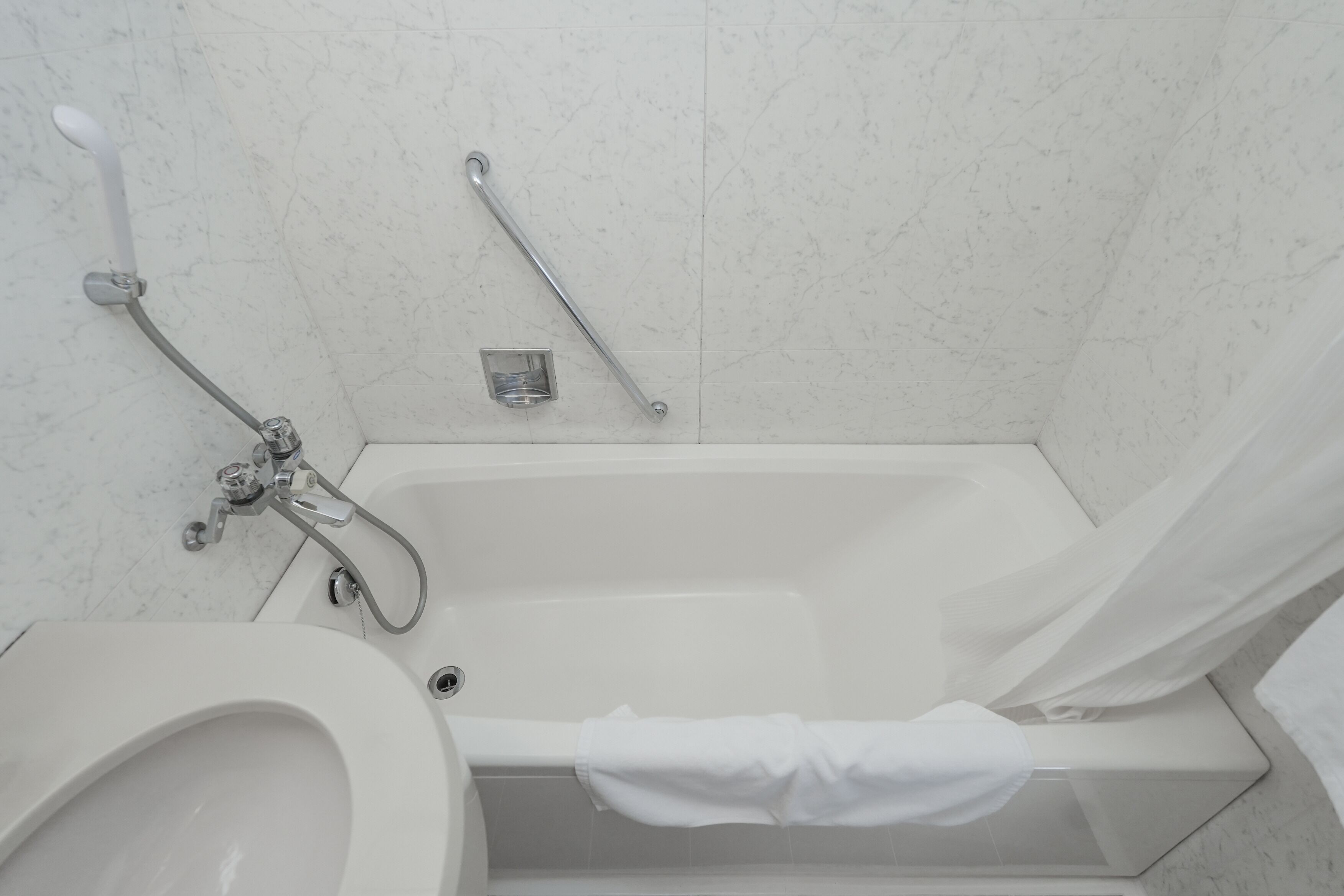 Ein Badezimmer mit Badewanne, Toilette und Duschbereich.