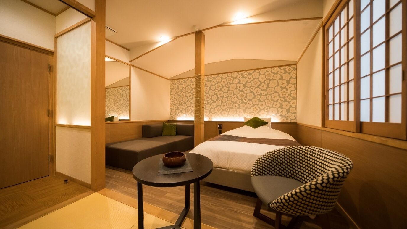 Una habitación con una cama, un sofá, una mesita y una silla.