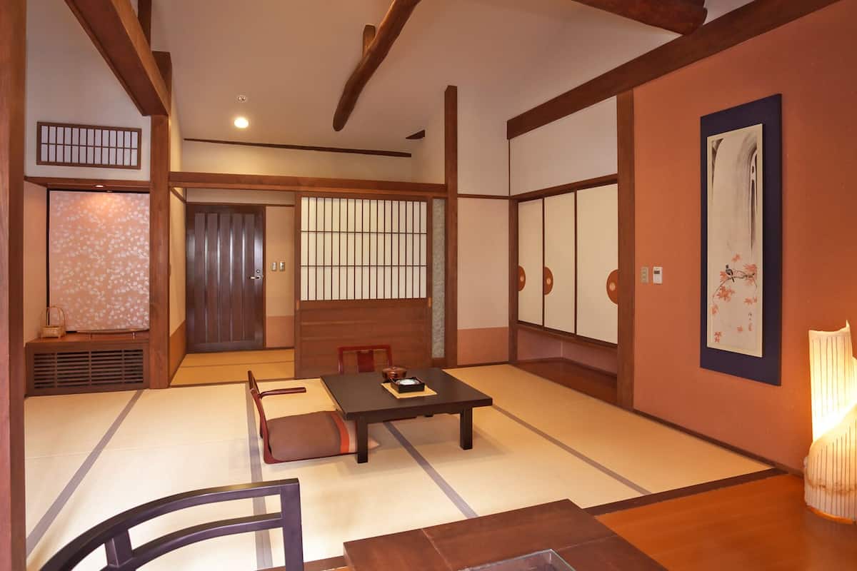 A traditional Japanese room with tatami flooring, a low table, and sliding doors.