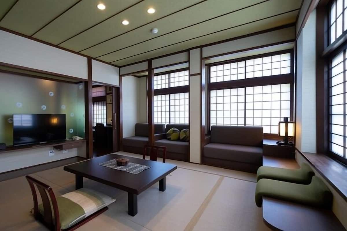 Una sala de estar tradicional japonesa, con suelo de tatami, una mesa baja y puertas correderas.