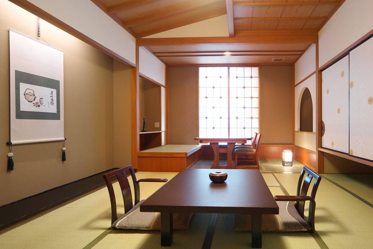 A traditional Japanese meeting room with tatami flooring, a low table, and sliding doors.