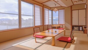 A traditional Japanese room with tatami flooring, a low table, and sliding doors. - Notsu Ryokan (Matsue)