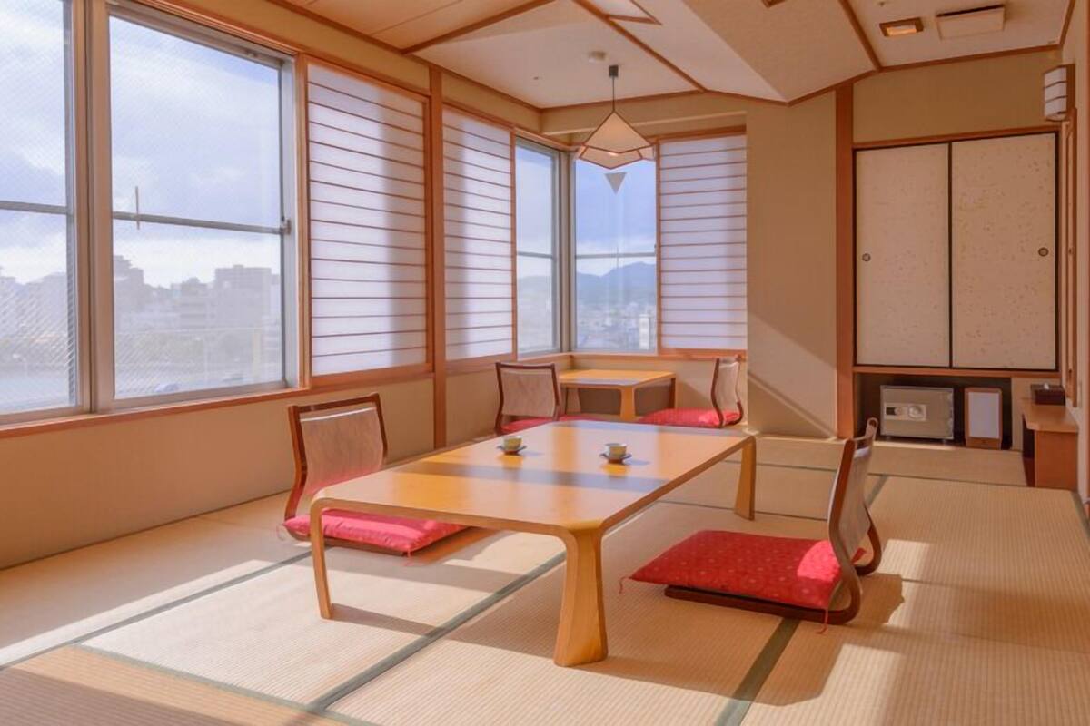 Una tradizionale stanza giapponese con pavimentazione in tatami, un tavolino basso e porte scorrevoli shoji.