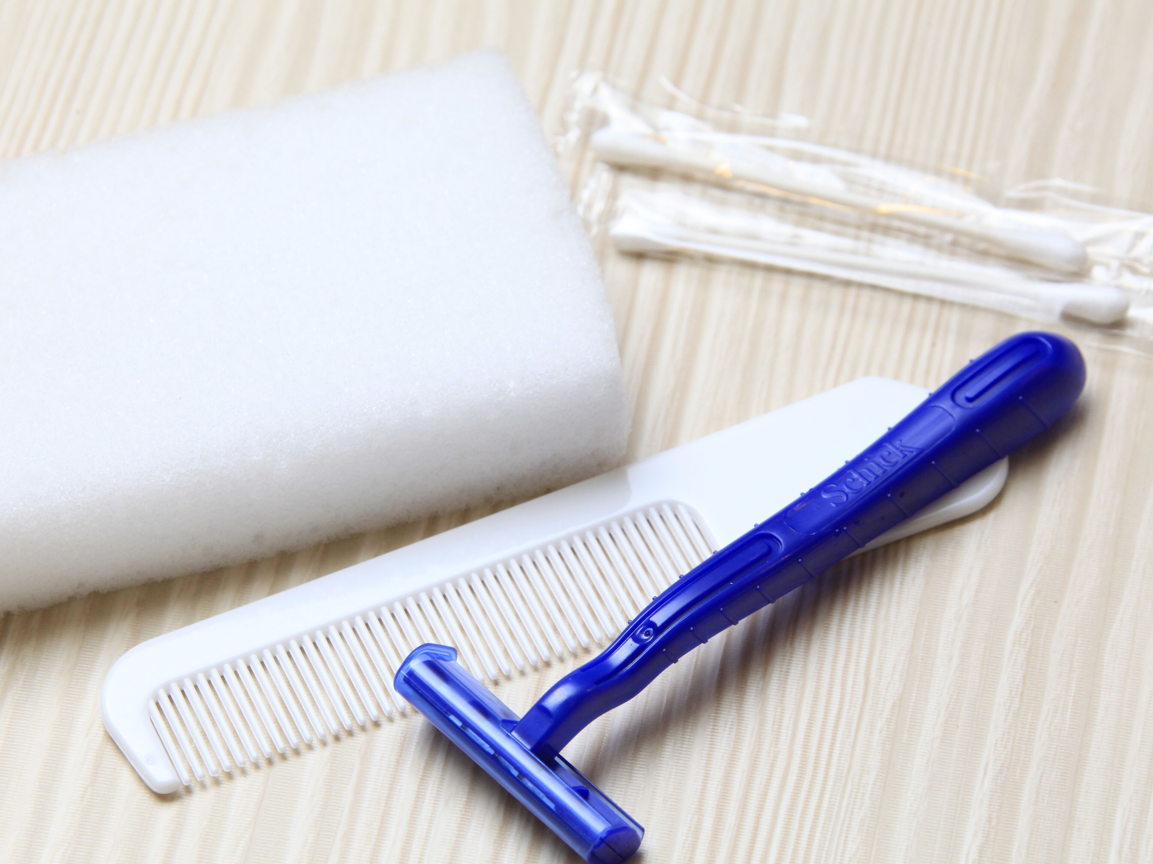 Un peigne, un rasoir et un savon sur une surface à rayures.