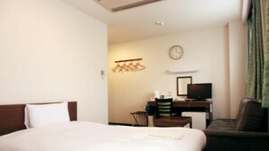 A hotel room with two beds, a desk with a computer, a chair, and a clock on the wall. - Hotel Green Line (Sendai)
