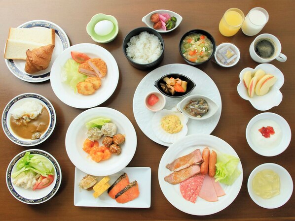 Una mesa con varios platos, incluyendo arroz, sopa y carne, además de salsas y bebidas.