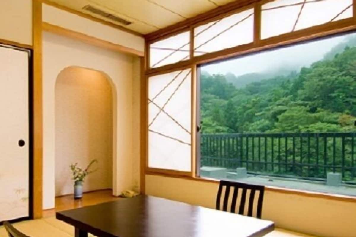 Ein traditioneller japanischer Raum mit Tatami-Böden, einem niedrigen Tisch und Stühlen.
