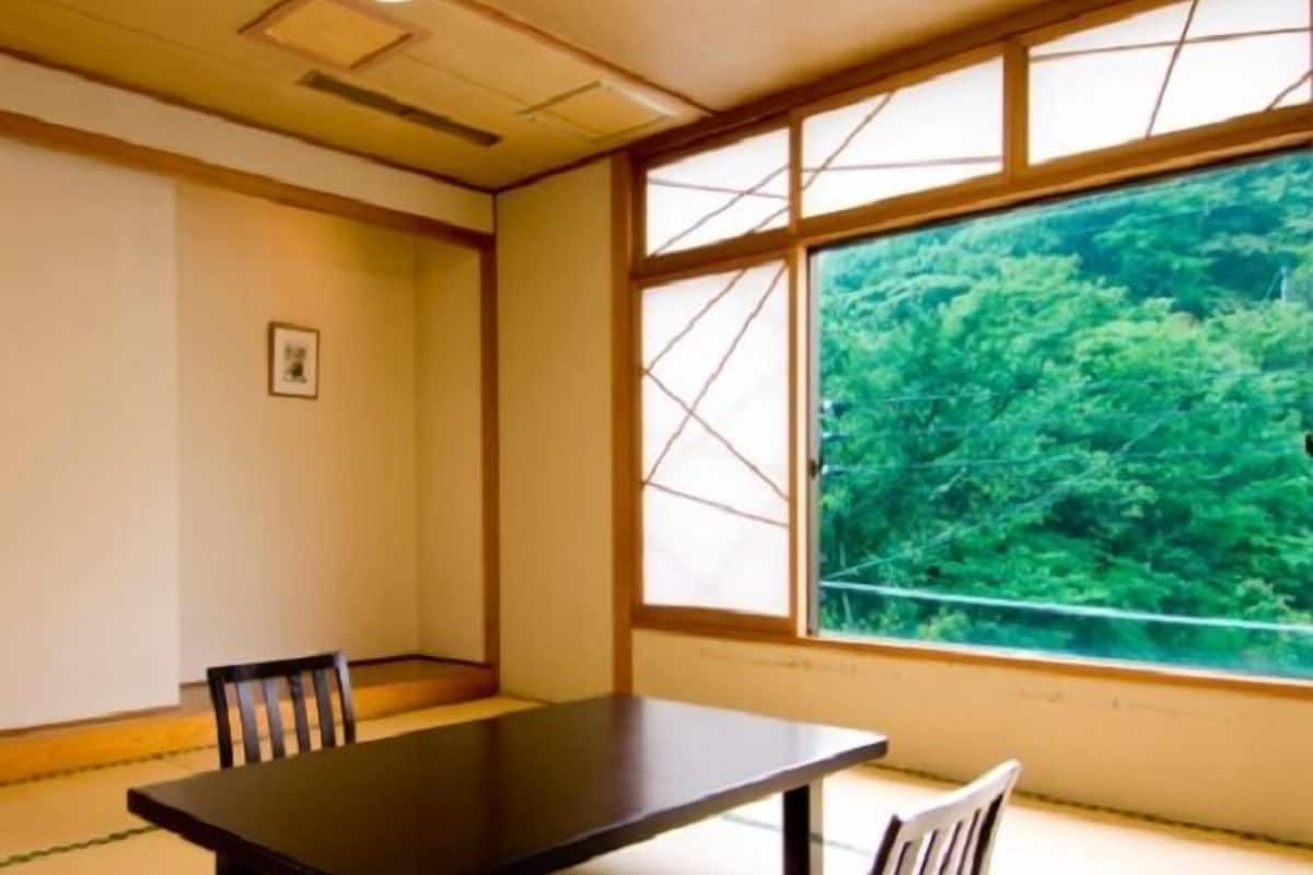 Ein traditioneller japanischer Raum mit Tatami-Boden, einem niedrigen Tisch und Stühlen.