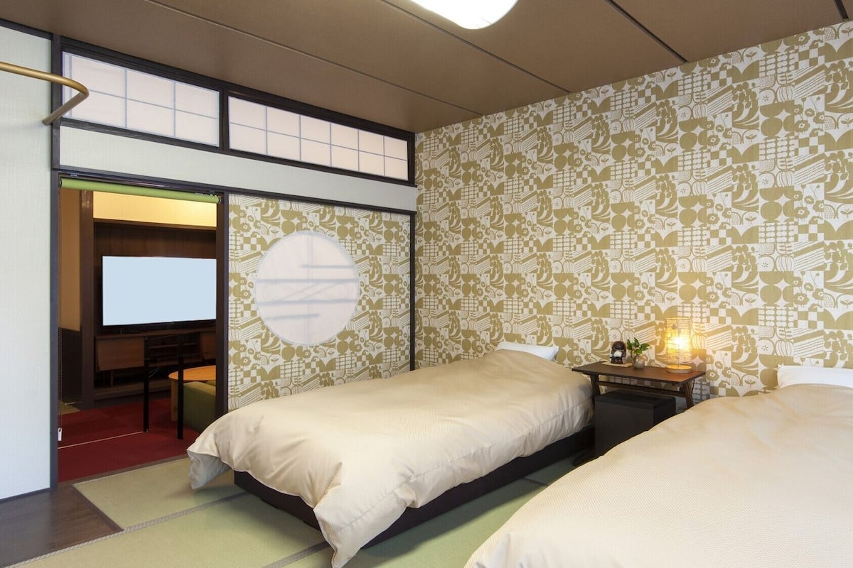Ein Hotelzimmer mit zwei Betten, einem Fernseher und einer Wand mit Muster.