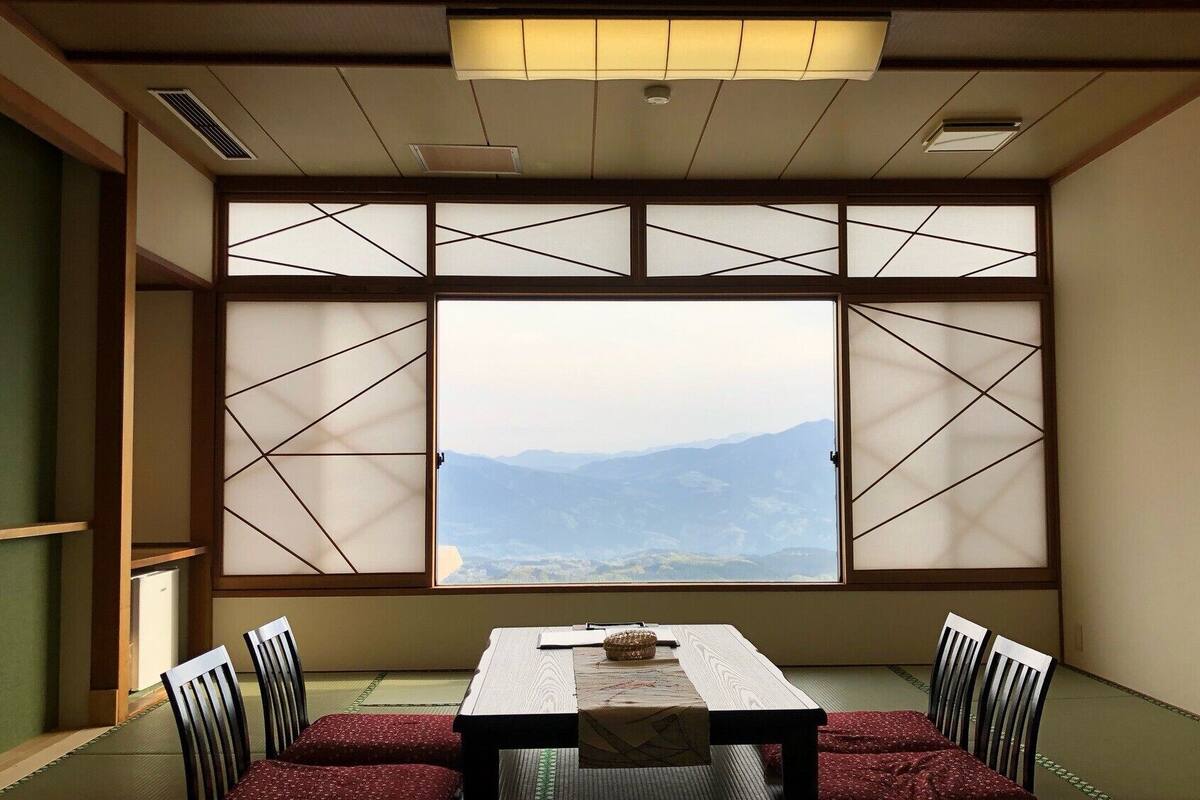 Ein traditioneller japanischer Raum mit Tatami-Bodenbelag, einem niedrigen Tisch und Shoji-Schirmen.