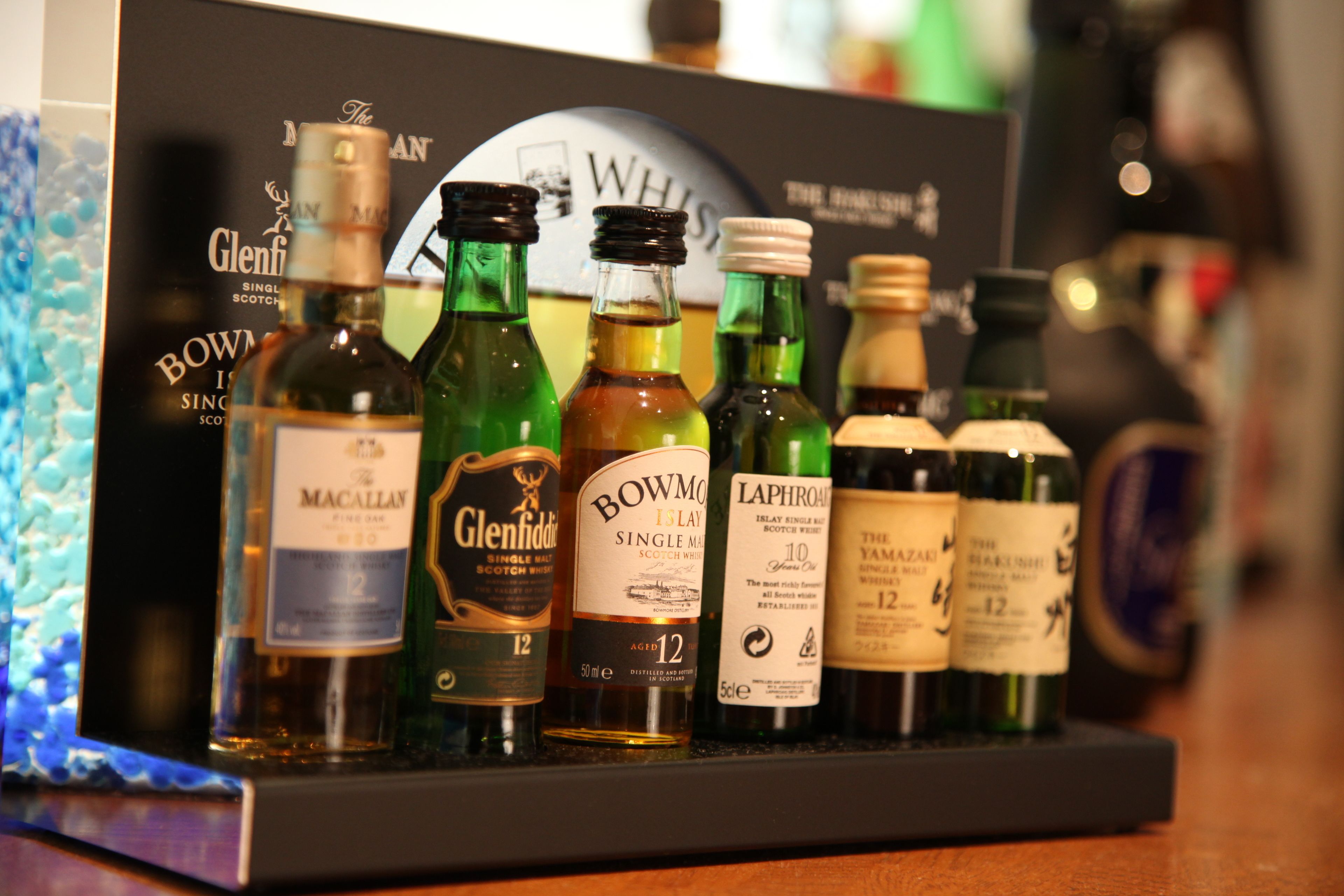 Varias botellas de whisky sobre una estantería.