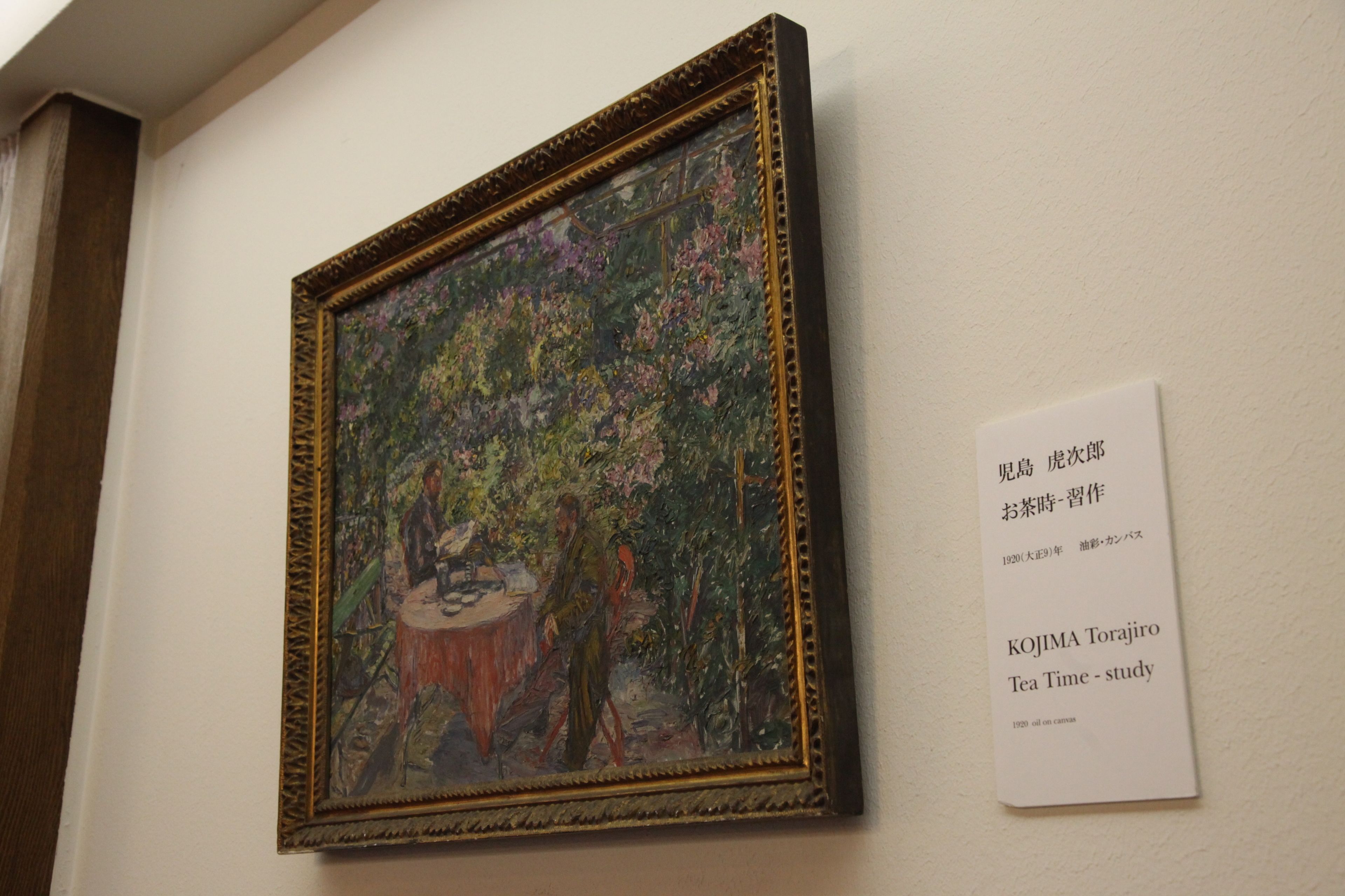 A framed painting with a descriptive label beside it.