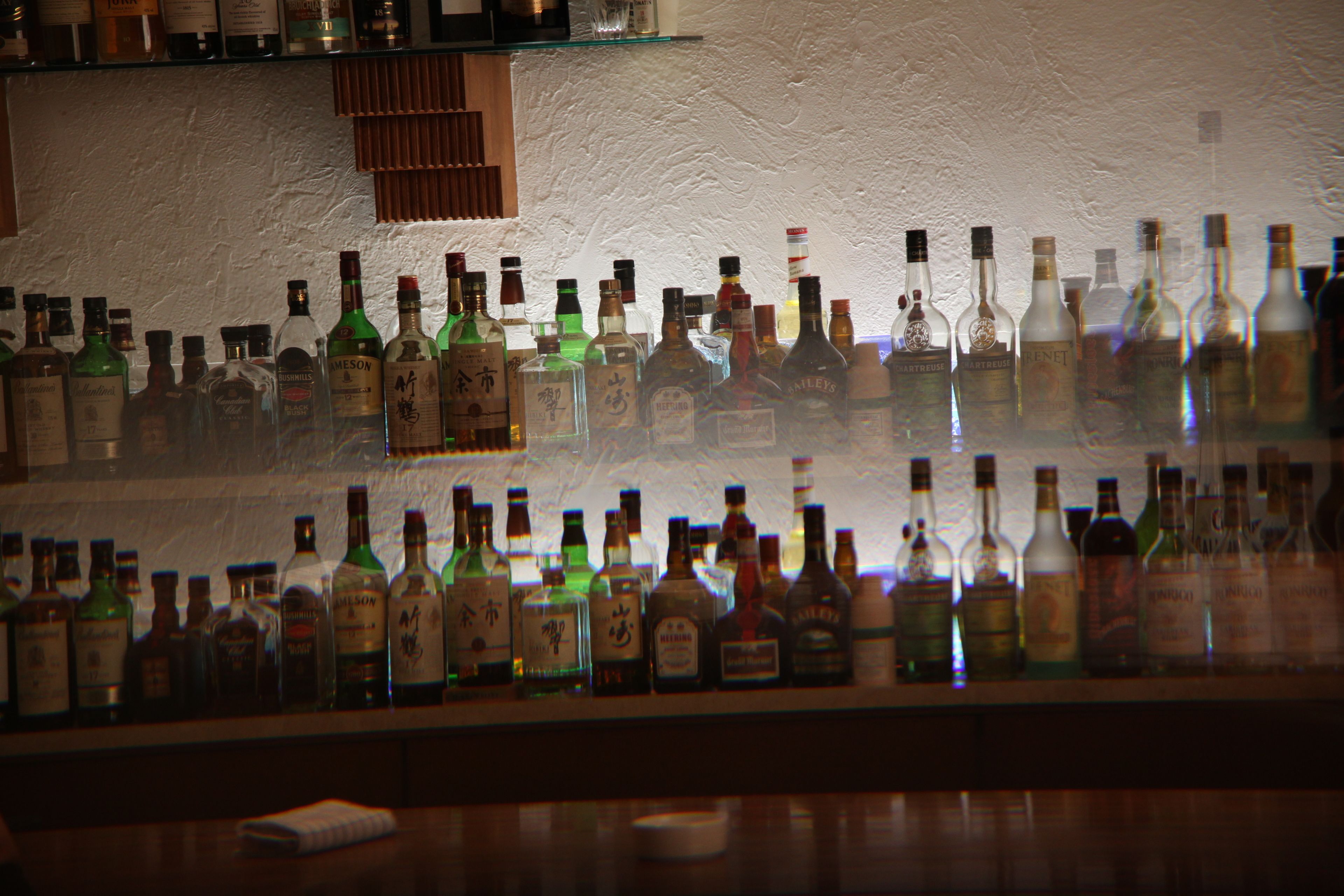 A bar with various bottles of liquor on shelves.