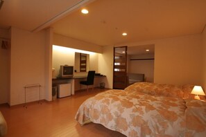 Cozy retreat with a single bed, desk, and TV.
