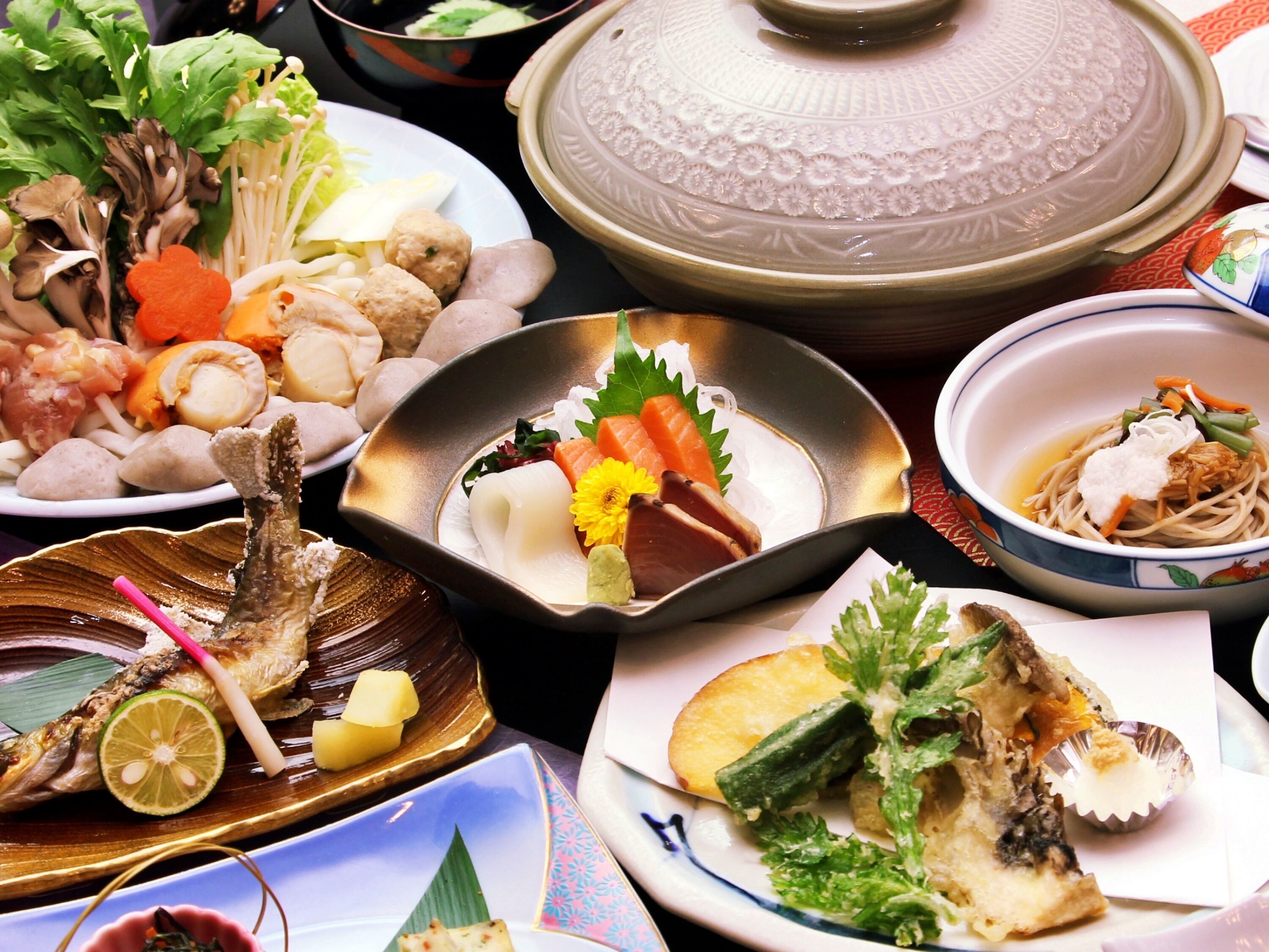 A variety of dishes including fish, vegetables, and noodles, suggesting a diverse meal selection.