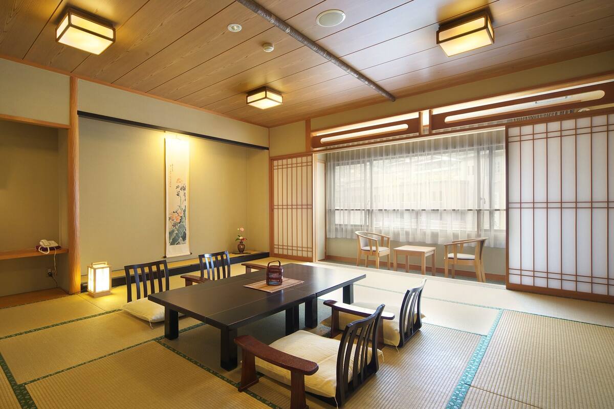 Um quarto em estilo japonês tradicional, com tatames, uma mesa baixa e painéis shoji.