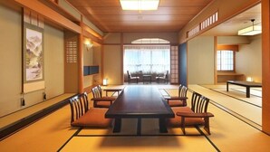 A traditional Japanese-style room with tatami flooring, a low table, and chairs. - Onyado Megumi (Yugawara)