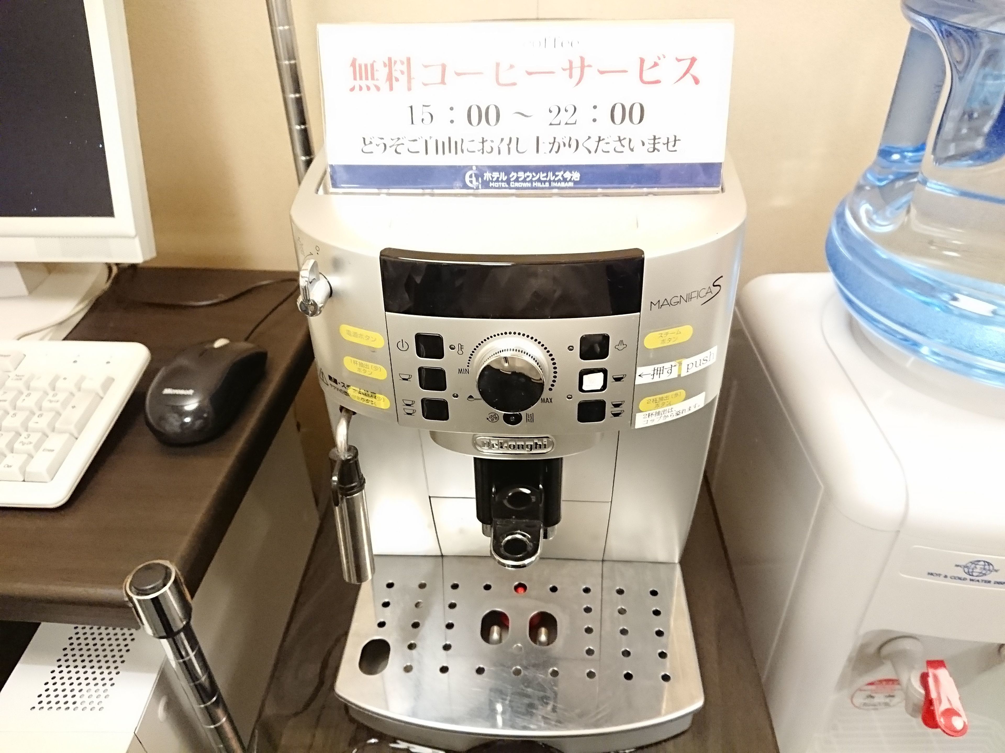 Een koffieapparaat met een digitaal scherm, een waterdispenser en een koffiezetapparaat op een aanrecht.