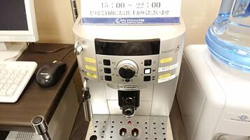 Een koffieapparaat met een digitaal scherm, een waterdispenser en een koffiezetapparaat op een aanrecht.