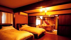 Habitación de hotel con dos camas, un rincón de comedor y una escalera.