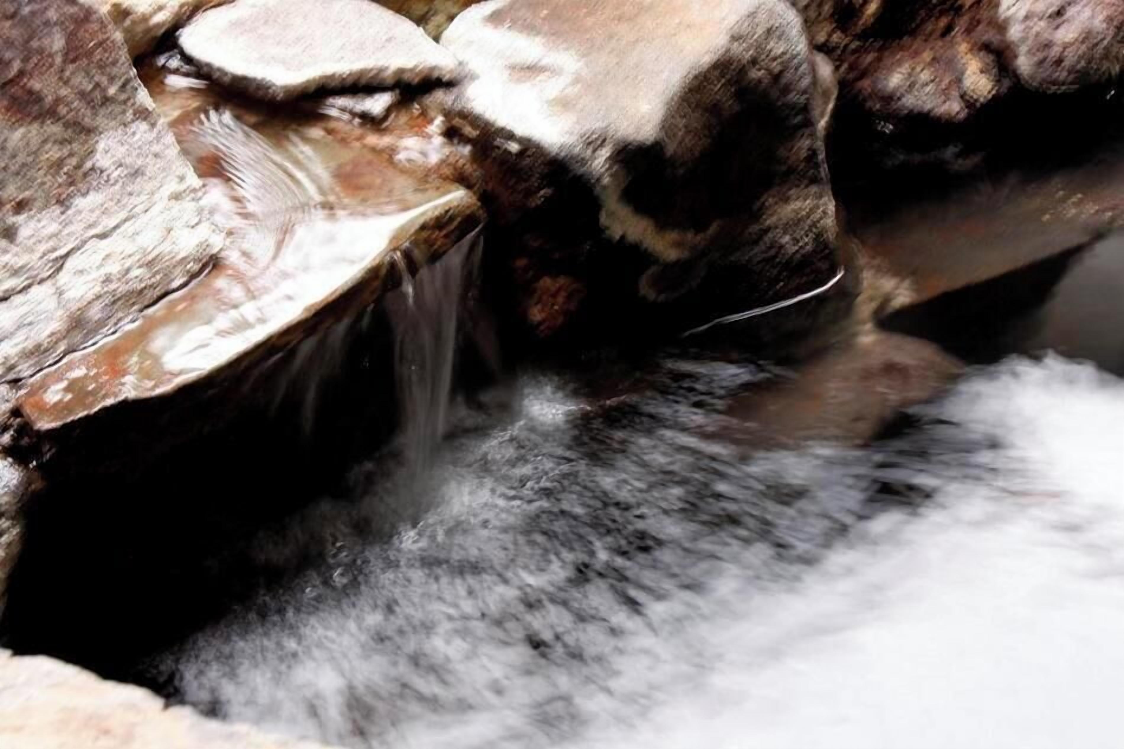 Une cascade artificielle où l’eau s’écoule sur des rochers.
