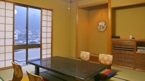Una habitación japonesa tradicional con suelo de tatami, una mesa baja y puertas correderas.