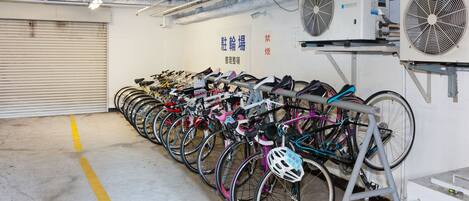 A bike rental facility with multiple bicycles and fans on the wall.