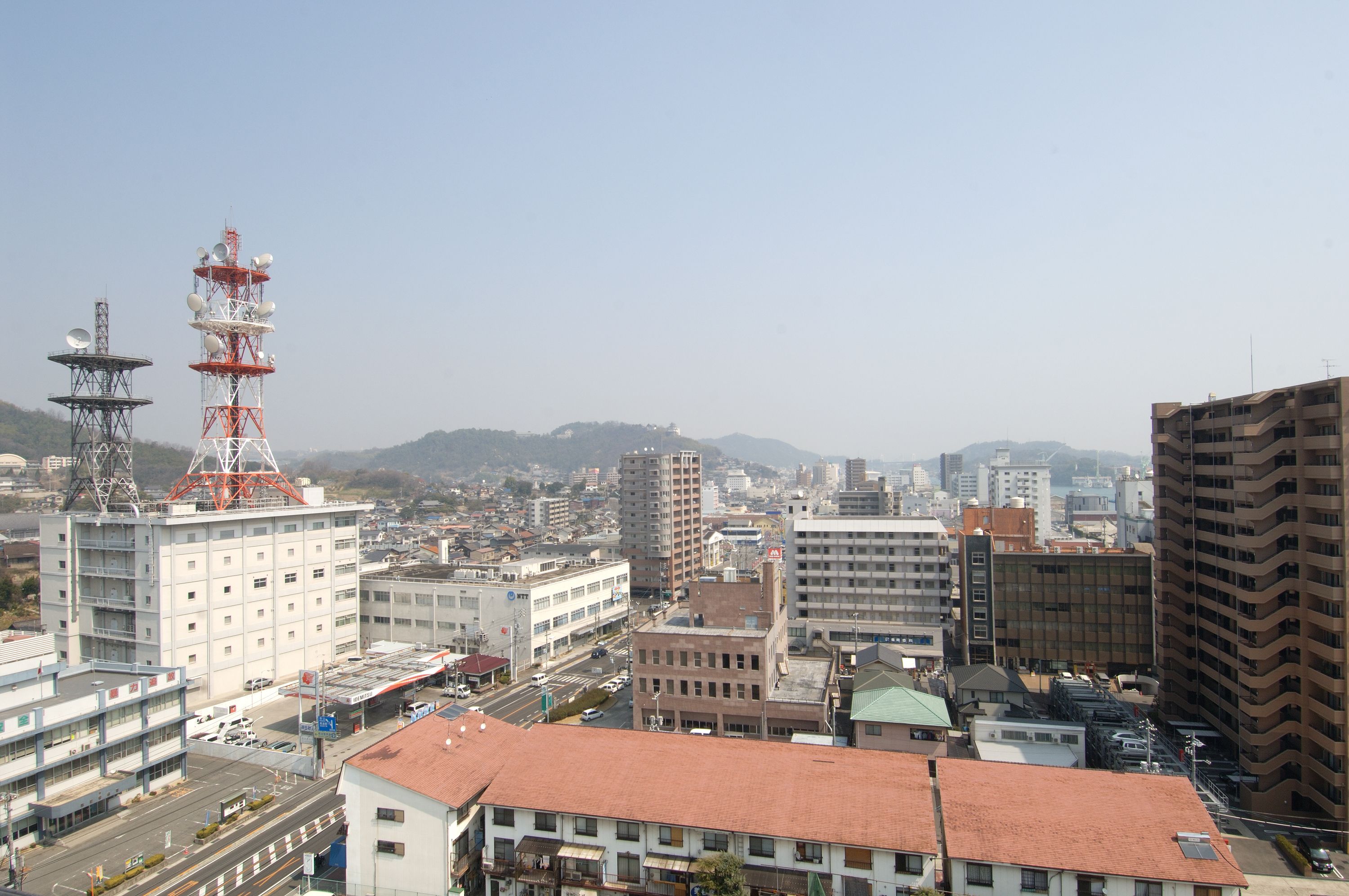 A cityscape with various buildings, including a prominent tower with antennas.