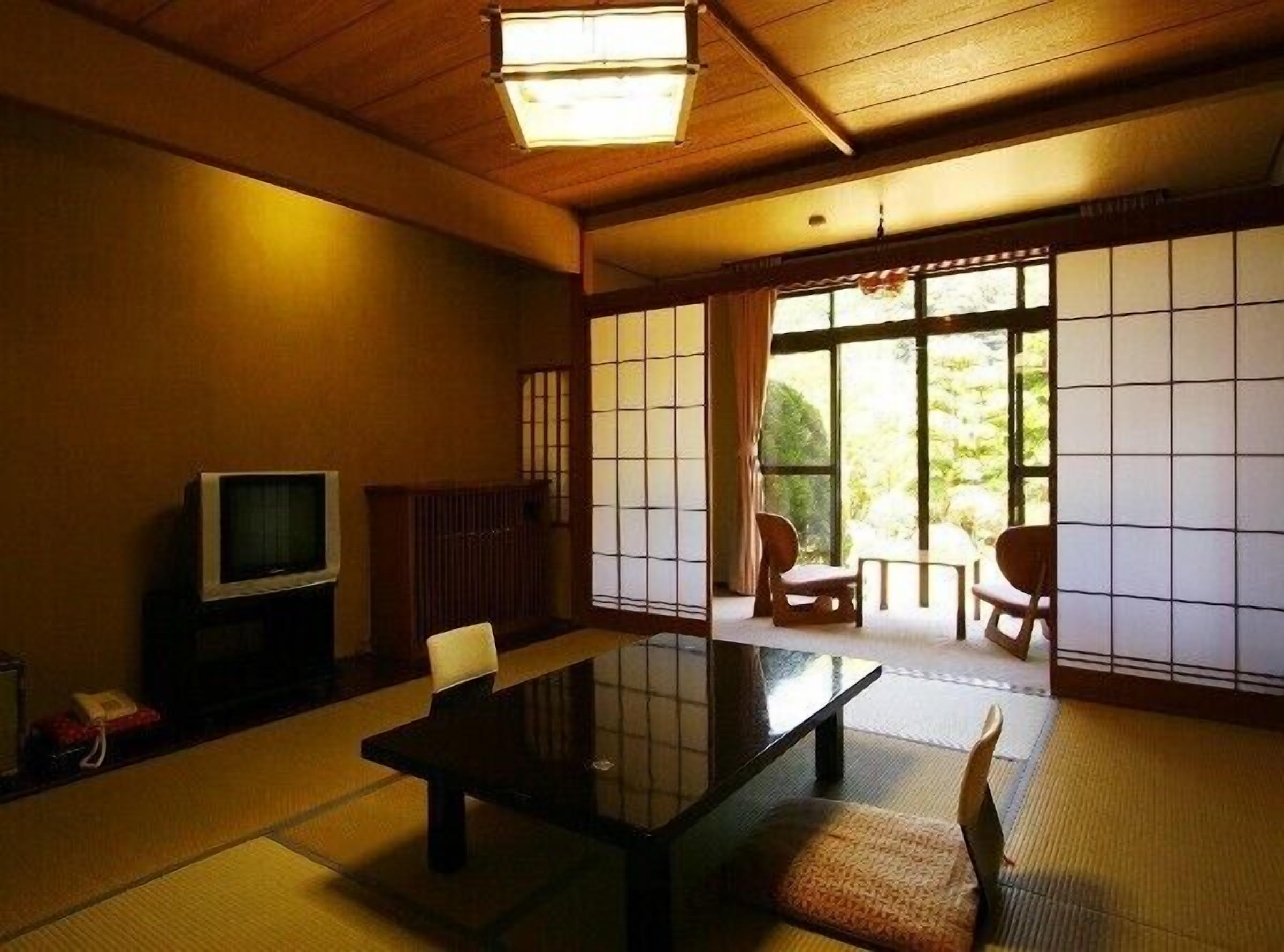 Ein traditioneller japanischer Raum mit Tatami-Böden, einem niedrigen Tisch und Schiebetüren.