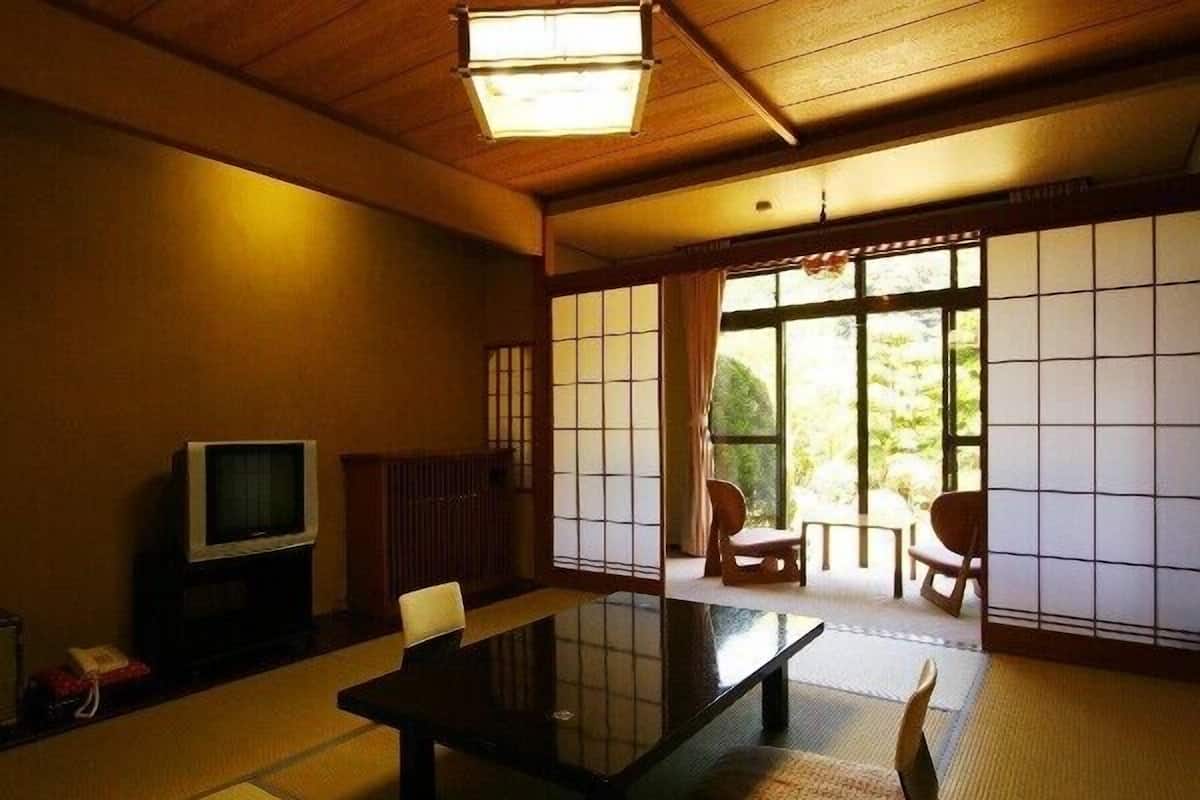 A traditional Japanese room with tatami flooring, a low table, and sliding doors.
