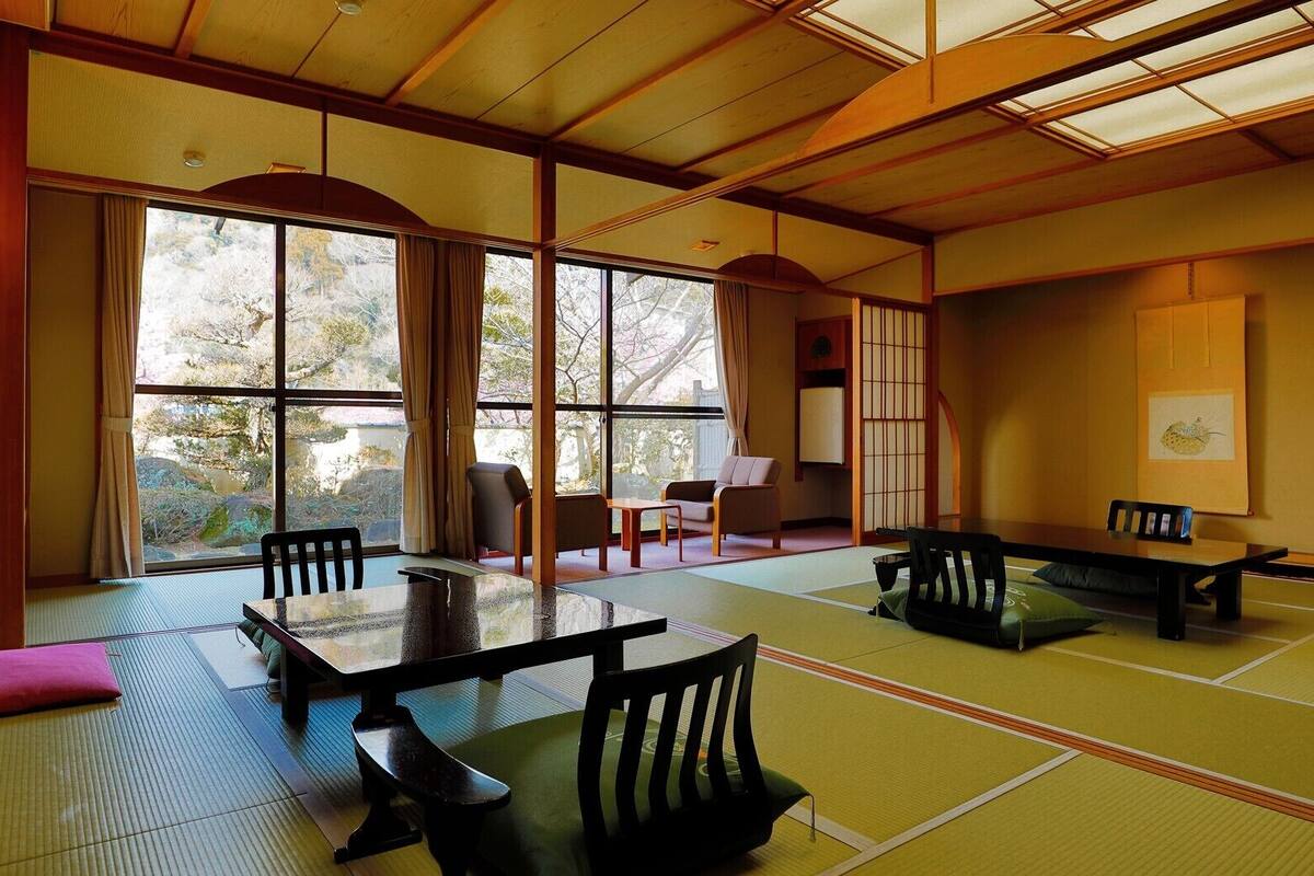 A traditional Japanese room with tatami flooring, a low table, and sliding doors.