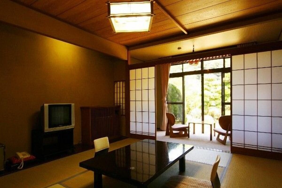 A traditional Japanese room with tatami flooring, a low table, and sliding doors.