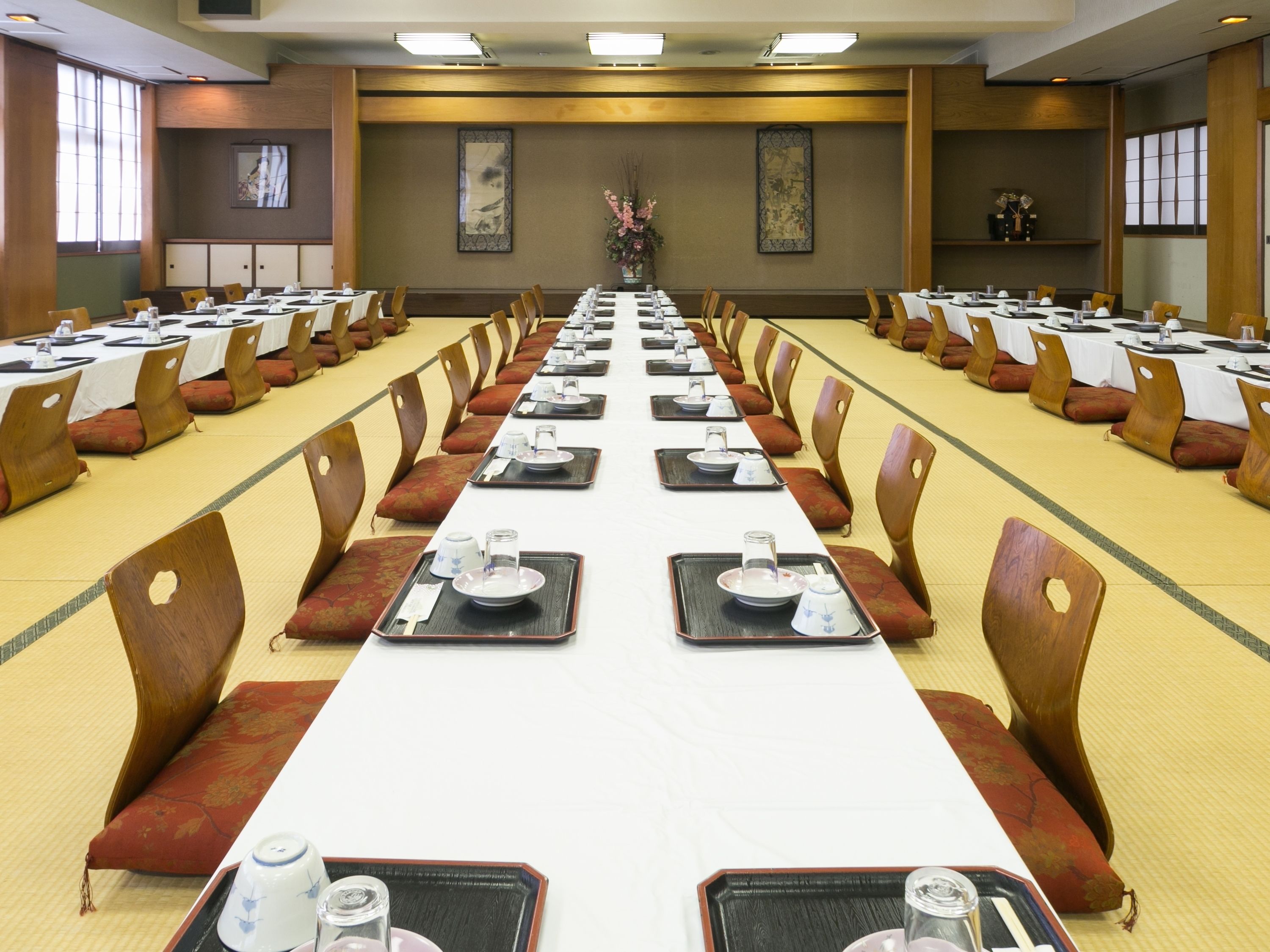 A conference room with long tables, chairs, and a central aisle.