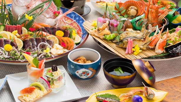Une variété de plats de fruits de mer, notamment du poisson, des crevettes et du crabe, présentés sur plusieurs assiettes et dans différents bols.